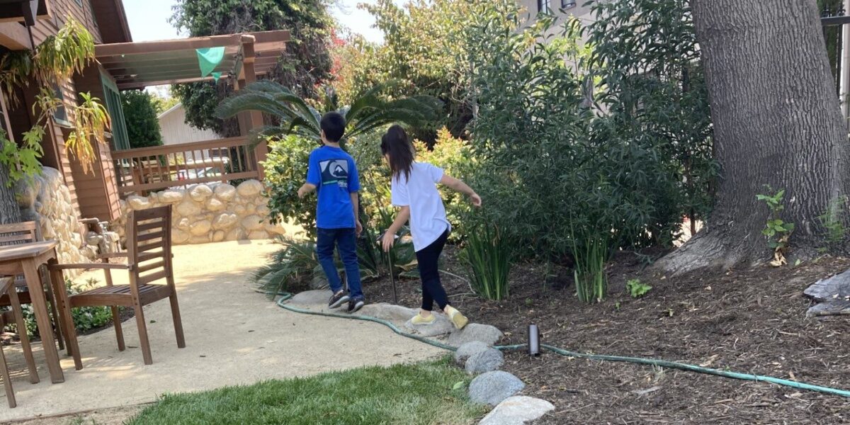 Two Academy students walking along a rock garden at IEA Learning Center
